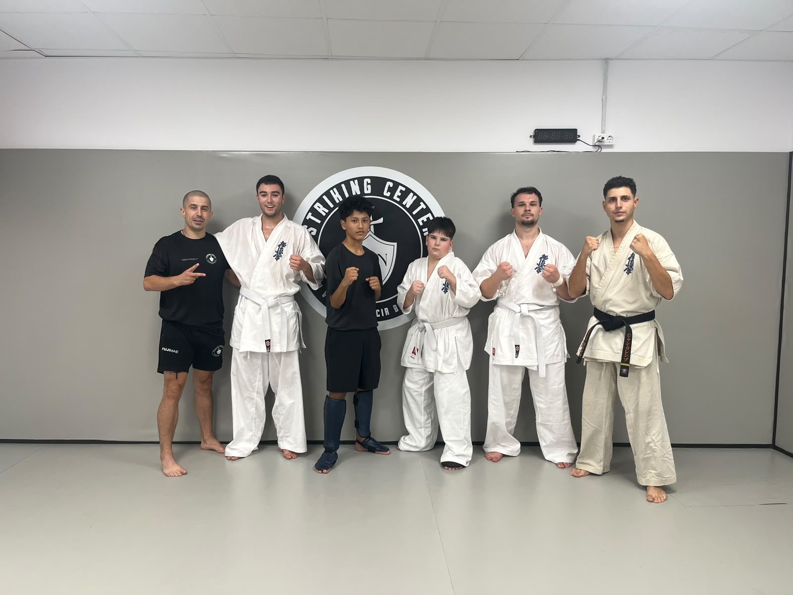 Grupo de alumnos y profesores de Striking Center BCN posando en el dojo